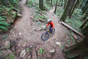 Fox Speedframe Pro mountain bike helmet and Pearl Izumi Mountain bike shoes riding up trail.