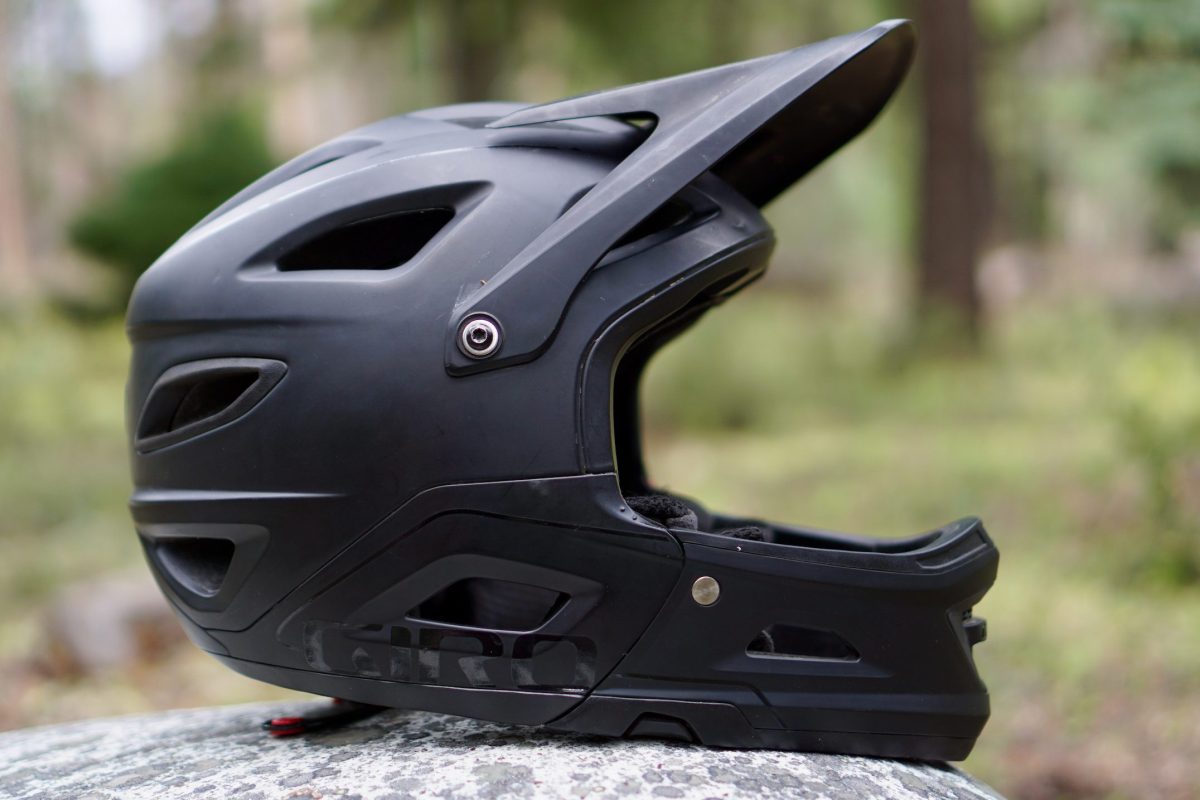 Black Giro Switchblade mountain bike helmet sitting on a rock.