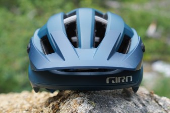 Dark blue Giro Manifest Spherical mountain bike helmet sitting on a rock (front view).