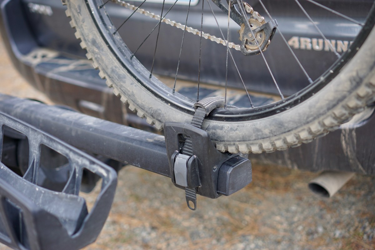 Rear wheel ratchet strap of Thule T2 Pro XTR hitch bike with mountain bike wheel mounted.