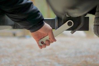 Using a tool to tighten the locking hitch pin on the RockyMounts AfterParty Swing Away hitch rack.